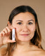 women holding lip balm by face